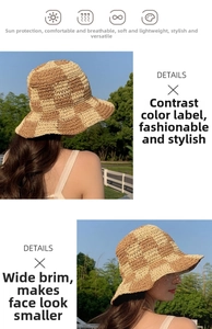 Close-up of hand-woven beige and brown checkerboard straw bucket hat with a wide brim