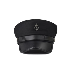 Detail of black nautical captain hat with silver anchor emblem and leather visor