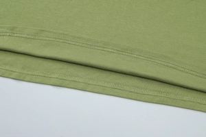 Close-up of green halter dress showing the fine knit fabric texture and high-quality stitching