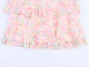 Détail de la robe en tulle rose avec broderie florale 3D et ornements en paillettes