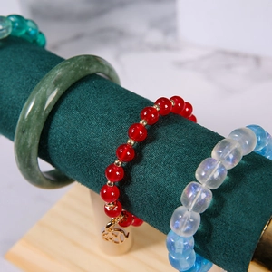 Dettaglio macro di bracciale in giada e perle su supporto in velluto verde