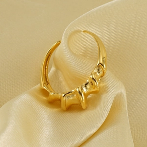 Minimalist 18K gold irregular wave open ring with artistic textured surface on silk