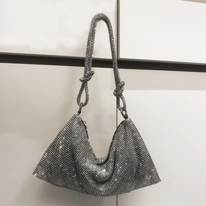 Detail of silver rhinestone evening bag featuring unique double knotted strap design