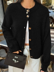 Détail des élégants boutons en écaille marron sur ce cardigan en maille noire