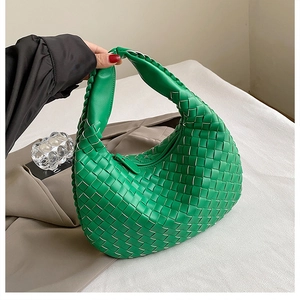 Detail view of a bright green woven leather hobo bag with signature knot and texture
