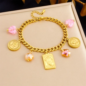 Detail of gold chain bracelet with vintage coin pendants and embossed portrait charms