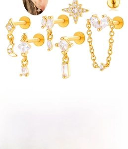 Macro detail showing heart chain and zircon stud earring specs in gold finish