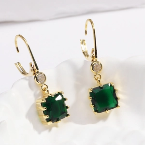 Détail de boucles d'oreilles carrées en cristal vert émeraude plaquées or 18 carats