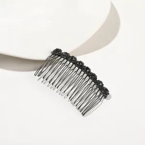 Detailed view of wave-shaped black metal hair comb with inlaid sparkling rhinestones