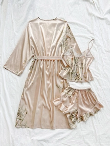 Detailed flat lay of a 3-piece champagne satin floral sleepwear set with silk texture