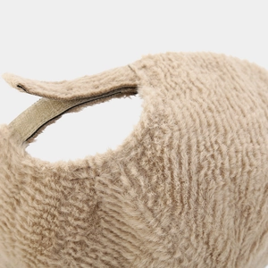 Détail d'une casquette beige en fausse fourrure avec fermeture réglable par bande velcro