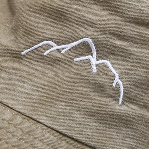 Washed khaki cotton bucket hat with white mountain embroidery for outdoor activities