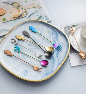 Flat lay of colorful 304 stainless steel dessert spoons and forks with unicorn star motifs