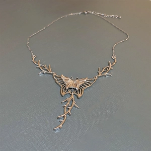 Detailed close-up of a silver butterfly necklace with Gothic thorn-style metal accents