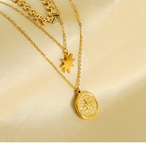 Nahaufnahme der goldenen Schichtkette mit Hexagramm und ovalem Stern-Reliefanhänger