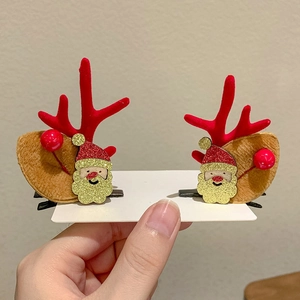 Detail of Christmas reindeer antler hair clips with Santa Claus and red berries decorations