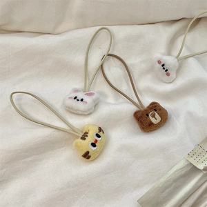 Close-up of soft plush animal charms with detailed embroidery and elastic hair bands