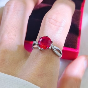 Detailed view of luxury 2-carat red ruby ring with six-prong setting and pavé diamonds