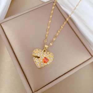 Close-up of heart pendant with red stone and pavé clear crystals on gold chain