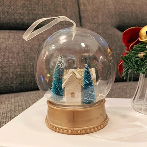 Christmas snow globe with white house, blue trees and golden base for holiday decor