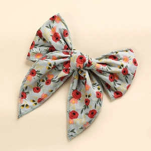 Detail of floral cotton bow hair clip with zigzag stitching and vintage pattern