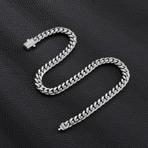 Detail of silver Cuban link chain with iced-out rhinestone buckle on black leather