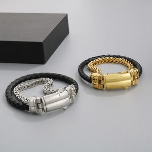 Detail of dual-layer black braided leather and stainless steel bracelets in gold and silver
