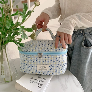 Gros plan d'une trousse à maquillage matelassée en coton sur une surface en marbre
