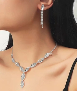 Close-up of model wearing a silver zircon tassel necklace and matching drop earrings