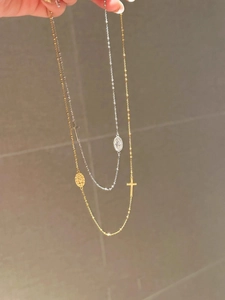 Gros plan de colliers croix en or et argent avec des pendentifs religieux ovales