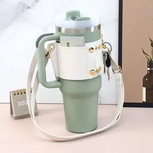 Close-up of mint green water bottle with cream leather carrier, card slot and gold studs