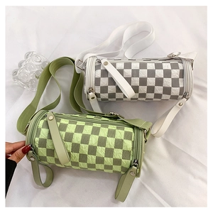 Detail of checkered cylinder bags with unique textured fabric and dual shoulder straps