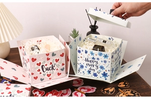 Détails d'un coffret cadeau surprise avec motifs cœurs et fleurs et papier de soie