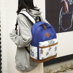 Lightweight navy floral backpack set with brown leather accents shown from a rear angle