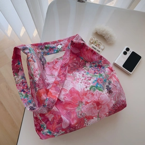 Detail shot of floral cotton tote bag with metal magnetic closure and wide shoulder strap