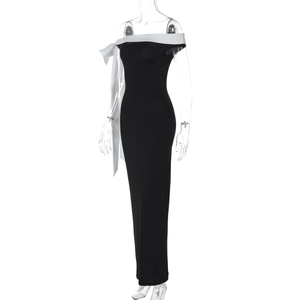 Detail of elegant off-shoulder black dress with white satin bow decoration on shoulder