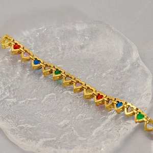 Detail of gold-plated tennis bracelet featuring rainbow heart-shaped cubic zirconia stones