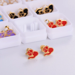 Close-up of cute red enamel mouse stud earrings in a white jewelry organizer box