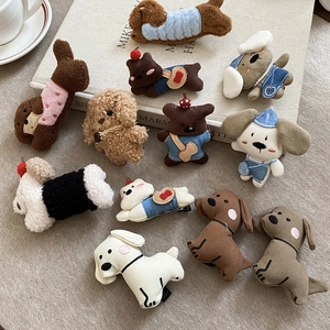 Detail of plush dog and teddy bear hair clips with soft textured fabric and metal duckbill grip