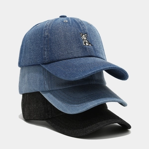 Washed denim baseball cap featuring cartoon dog embroidery in navy blue, light blue, and black