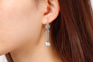Close-up of minimalist silver long drop earrings with pearls on a model side profile