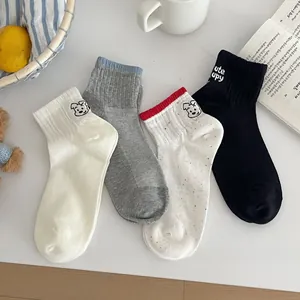 Close-up of four pairs of cotton socks featuring cute dog embroidery in various colors