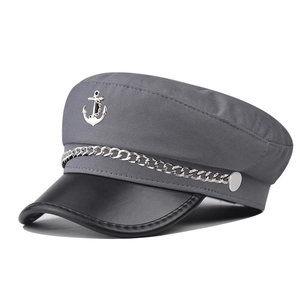 Close-up of anchor emblem and silver chain on a grey nautical fiddler cap detail