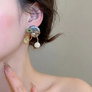 Boucles d'oreilles rétro perlées avec disque argenté et perles en bois sur un mannequin