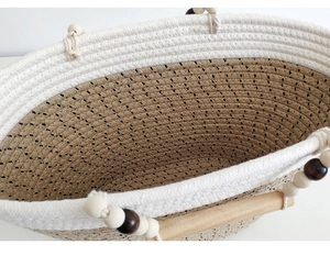 Detail of woven cotton rope tote with wooden handles and decorative beads accent