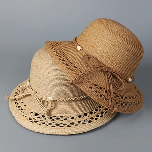 Detail von Raffia-Sonnenhüten mit feiner Webstruktur, Perlen und Schleifenakzent