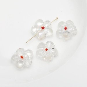 Detailed view of clear glass flower beads with red centers for DIY jewelry crafting