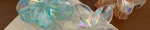 Macro detail of iridescent plumeria hair claws showing translucent rainbow resin textures