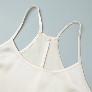 Close-up of pearl white satin dress straps with racerback design and size S label detail