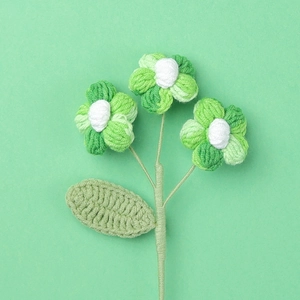 Detailed view of handmade crochet puff flowers with green gradient petals and leaf